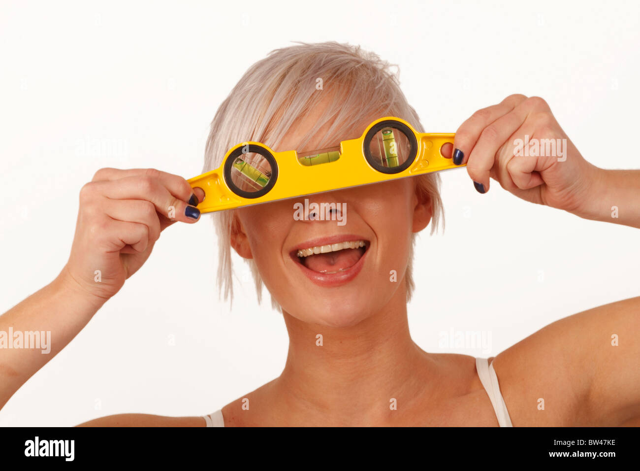 young woman holding a spirit level as part of an apprenticeship course  or training scheme Stock Photo