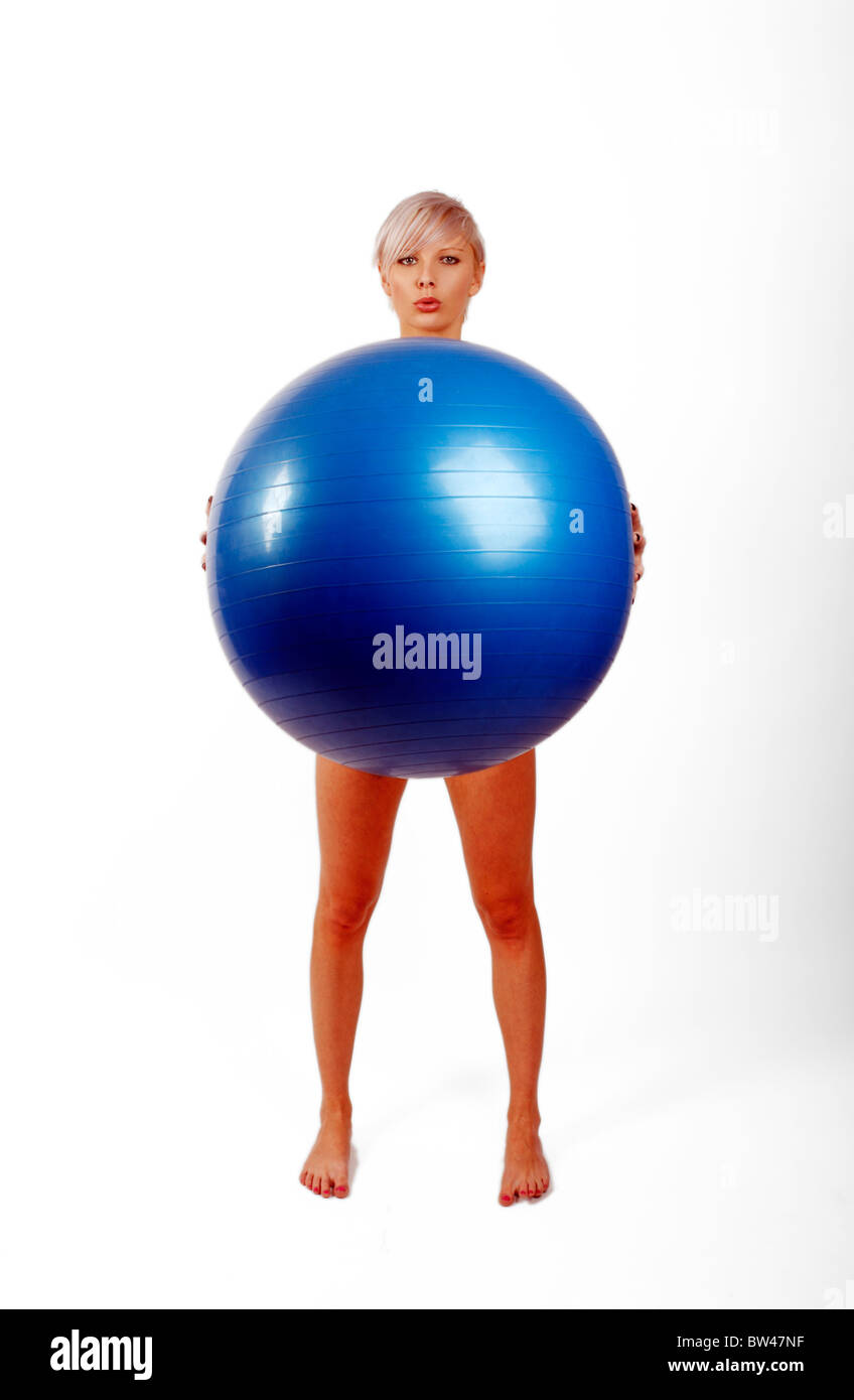 young woman holding a swiss gym ball and using it to improve her core ...