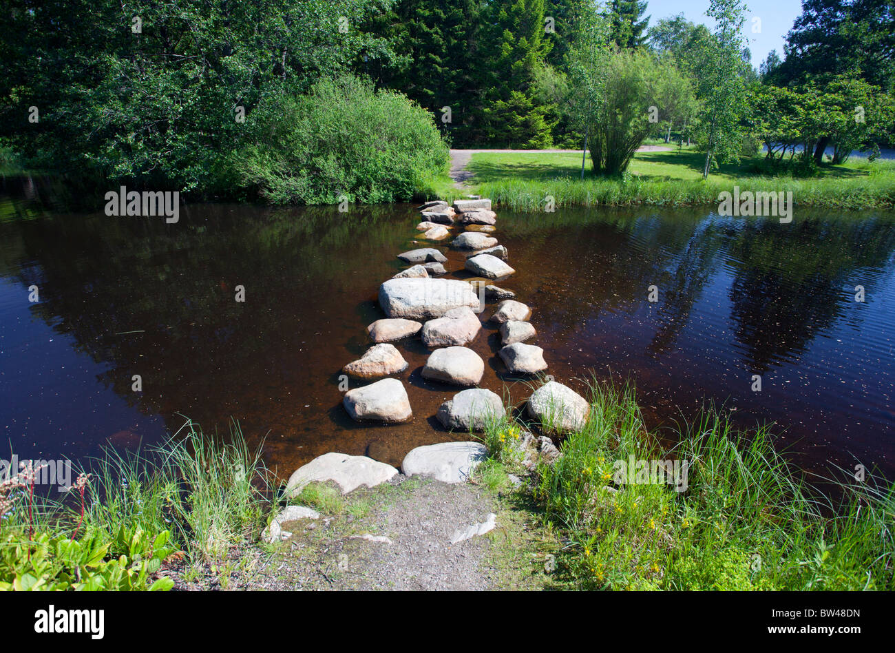 Garden pond water crossing using stepping stones  , Finland Stock Photo