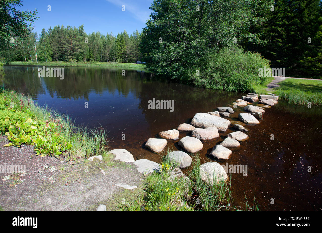 Stepping stones over a small garden pond , Finland Stock Photo
