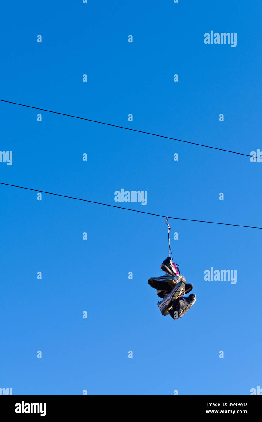 Trainers hanging from a telephone line Stock Photo