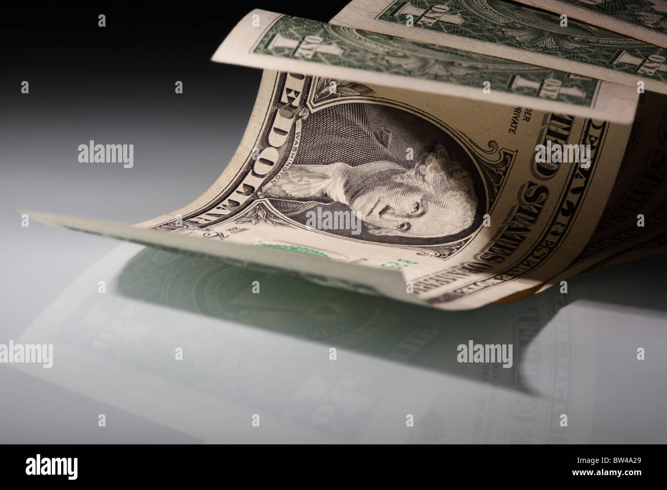 Money. US Dollars on a glass surface in a floodlit. Copy-space. Shallow DOF. Stock Photo