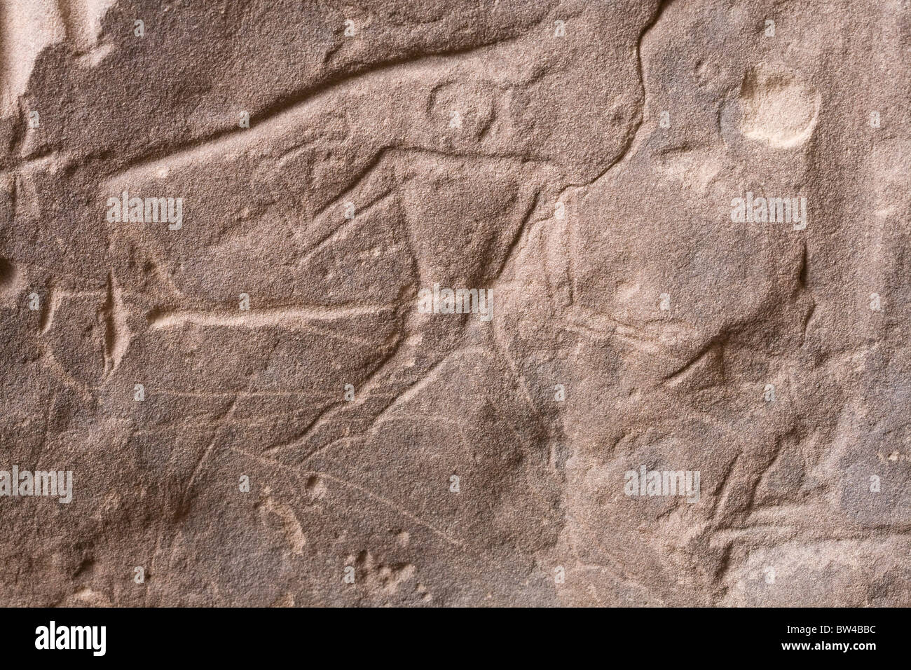 Deep scratched depiction of man holding a round headed mace striding in-to action in the Eastern Desert, Egypt Stock Photo
