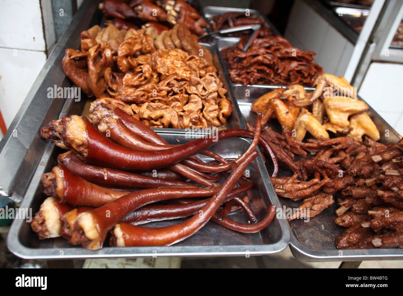 Pigs tails and chicken feet on display at the large local food market in Kunming, Yunnan Province, China. Stock Photo