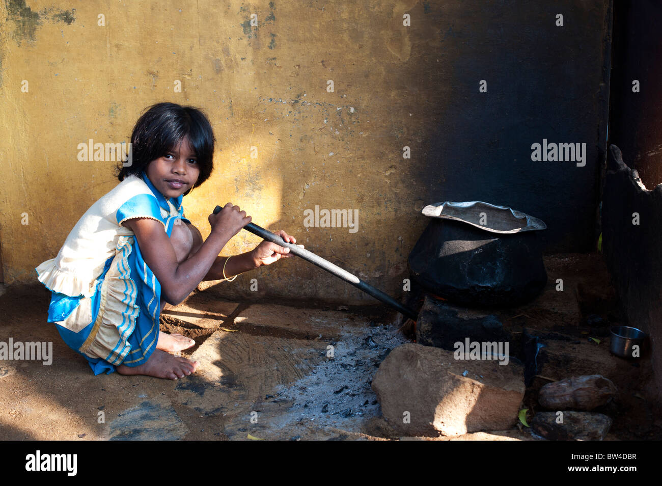 Rural Indian girl outside her home stoking and blowing the fire for cooking  rice in a rural indian village. Andhra Pradesh, India Stock Photo - Alamy