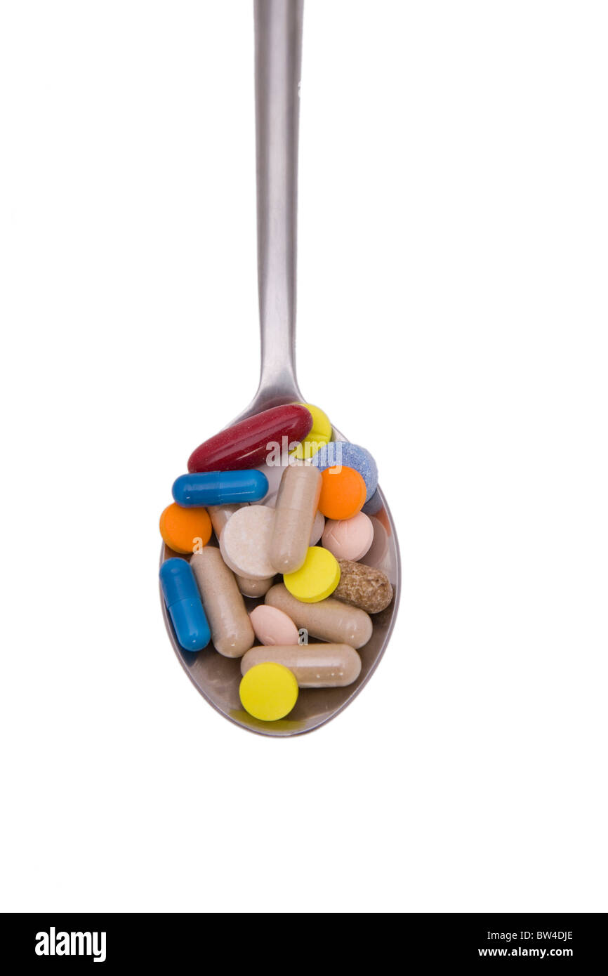 Teaspoon with pills and capsules isolated on white background Stock Photo