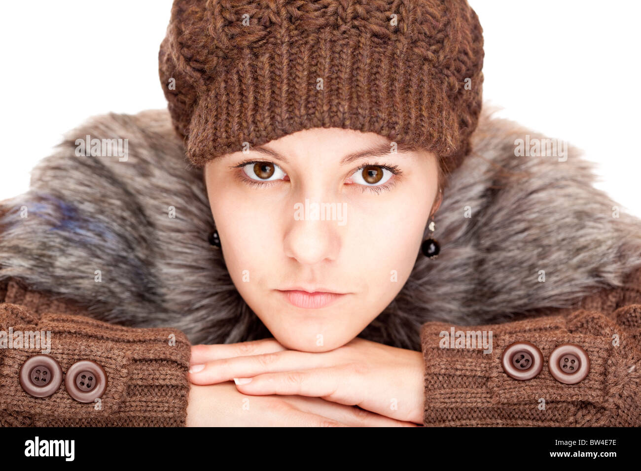 Beautiful young woman with pullover and cap looks serious. Isolated on white background. Stock Photo