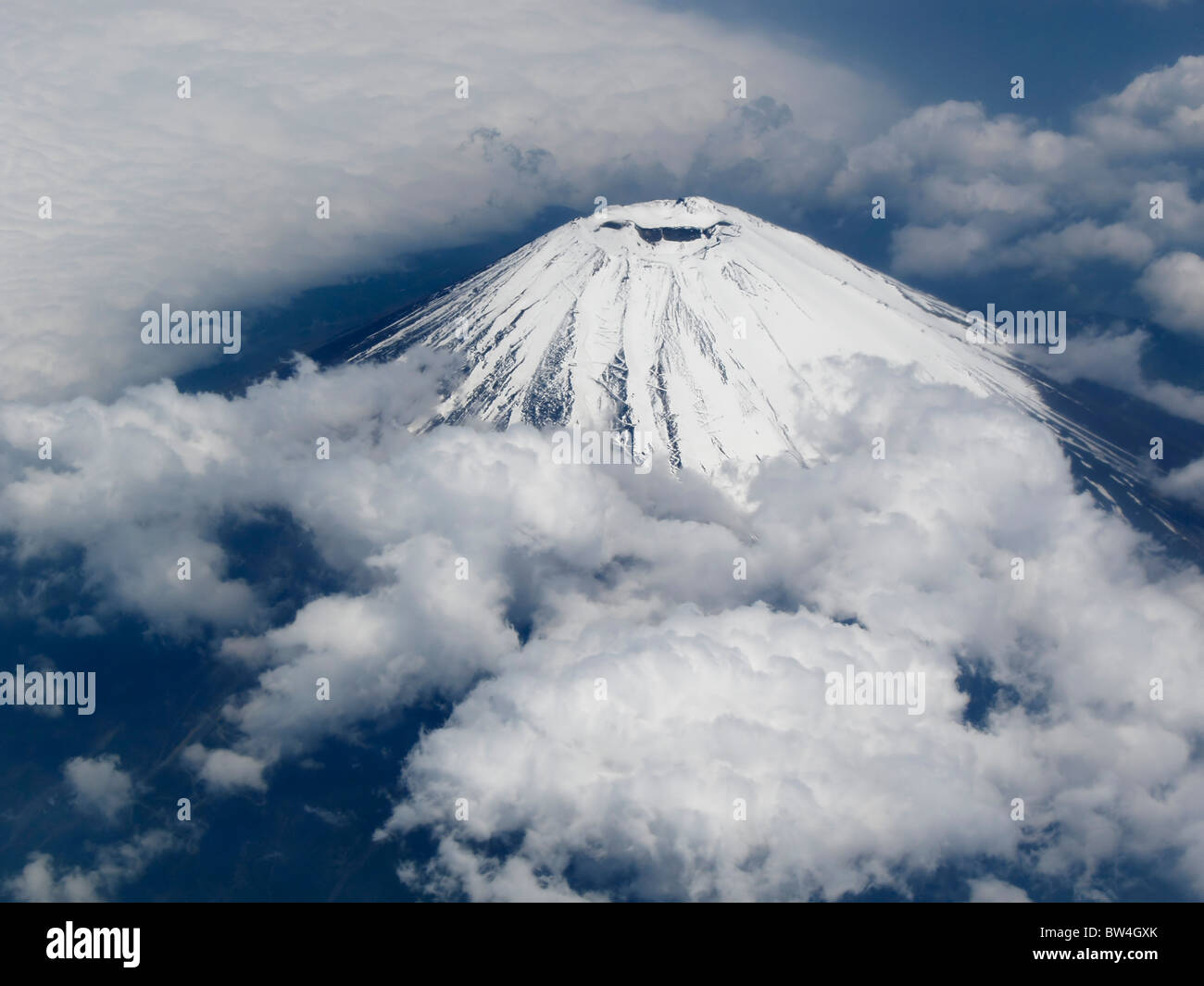 The snow covered peak of Fuji San (Fujiyama) in early summer seen from an airplane, Yamanashi Japan JP Stock Photo