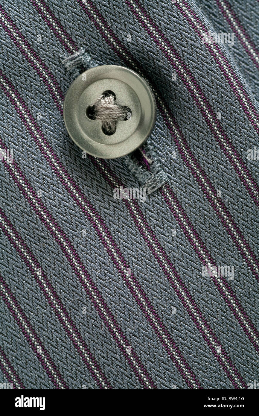 Close up image of the button and button hole on a man's striped shirt
