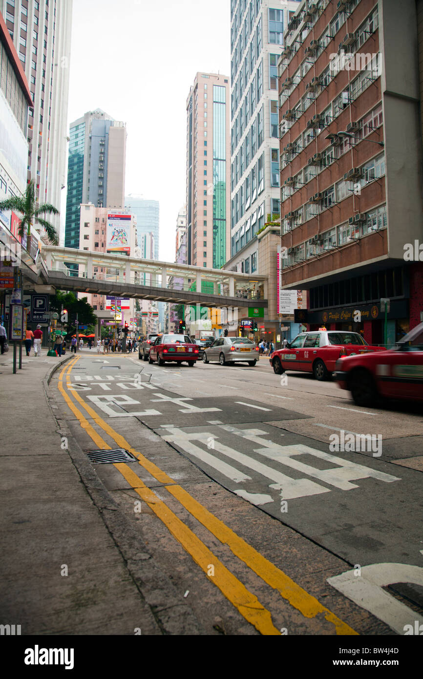 Not far from central Hong Kong, the Wan Chai neighborhood with cars speeding under overhead walkway Stock Photo