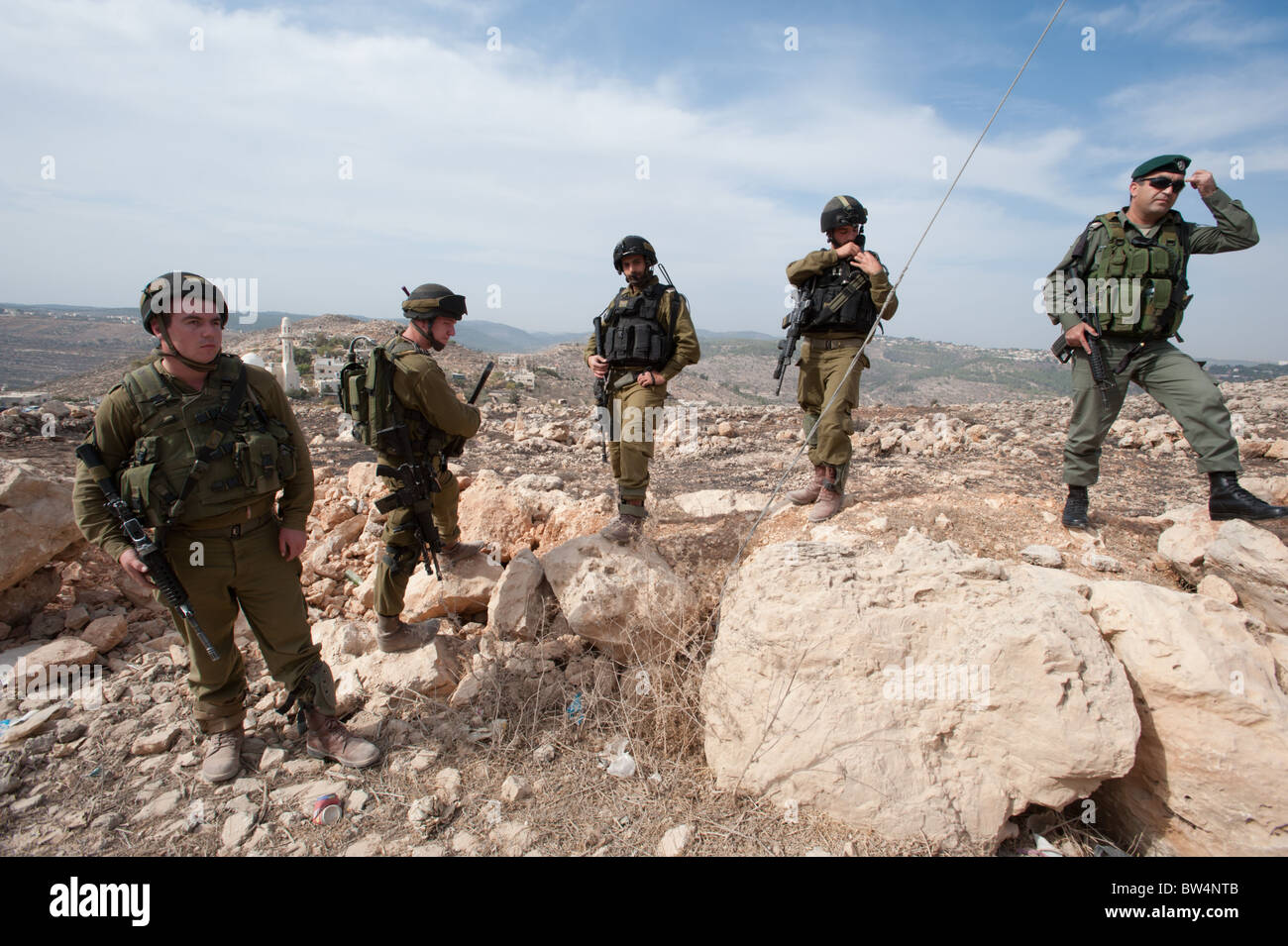 Heavily armed Israeli soldiers stand by during a nonviolent protest against the Israeli separation barrier in Al-Walaja. Stock Photo