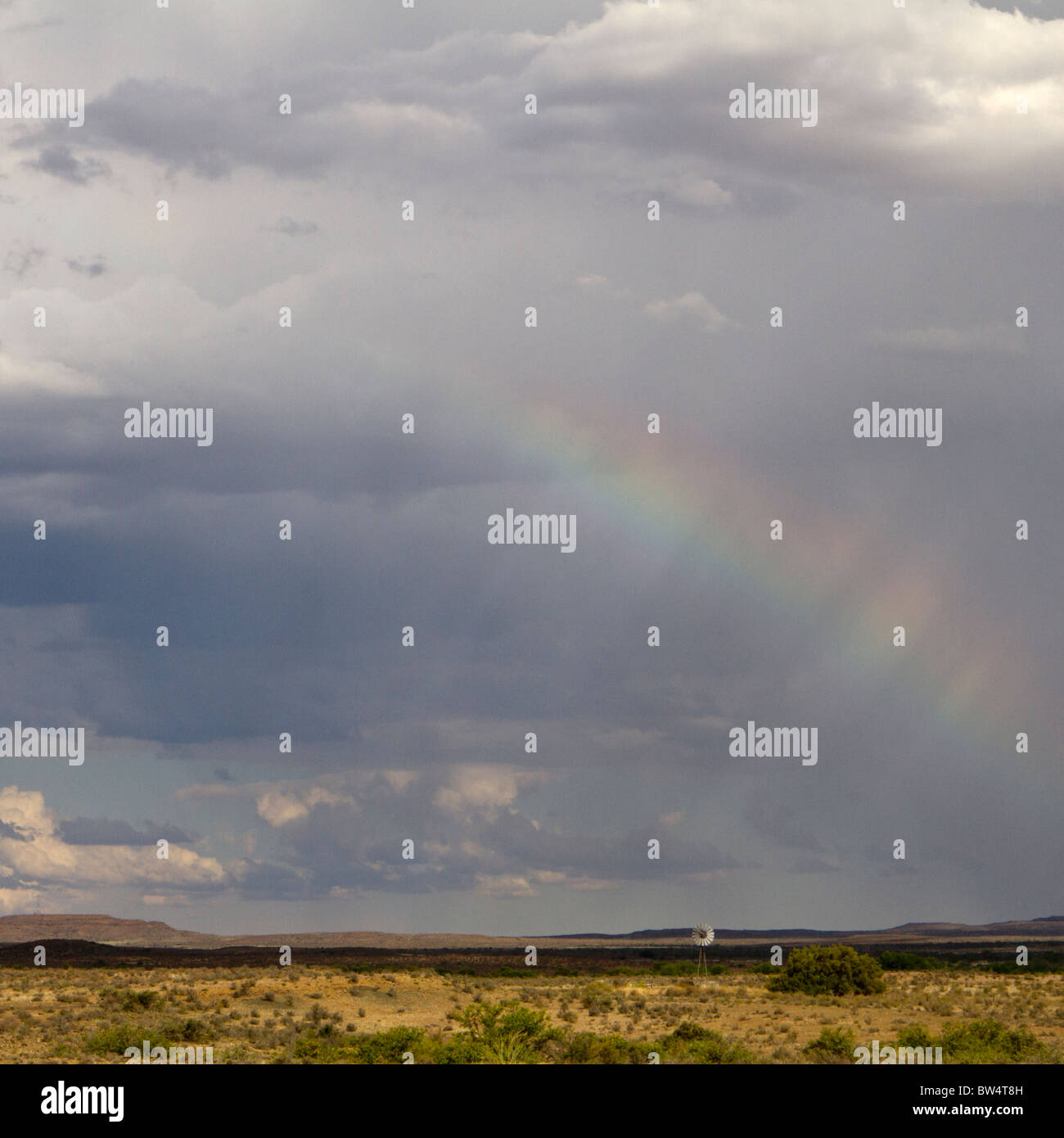 Cloudy sky with distant rain and rainbow Stock Photo