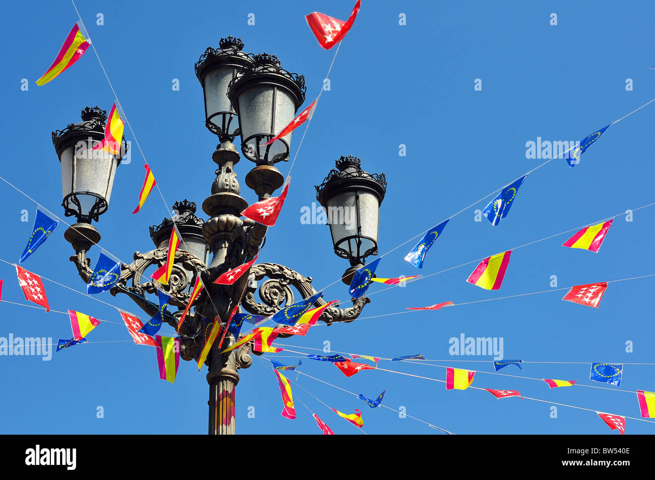 Pole with many flags against blue sky Stock Photo