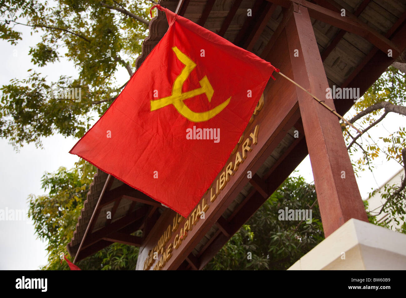 The hammer and sickle flag of communism flies at the gate of Vientiane's library on Lane Xiang Avenue Stock Photo