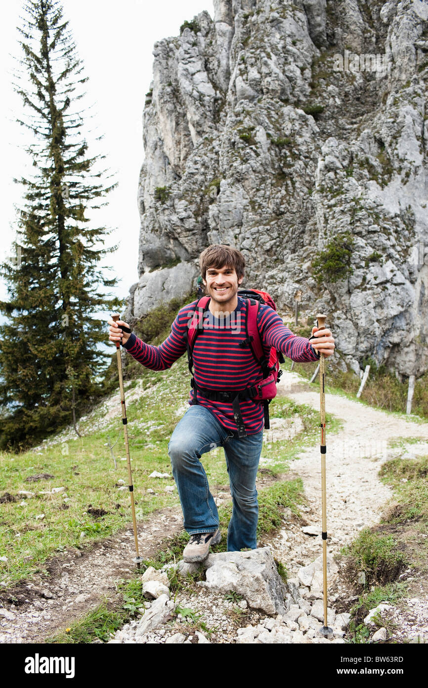 Man with hiking poles on mountain trail Stock Photo