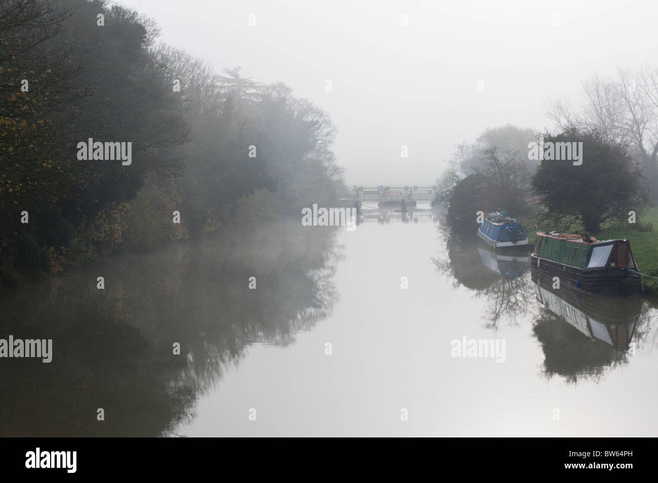 Narrowboats on the Thames just upstream from Godstow Lock on a misty day. Stock Photo