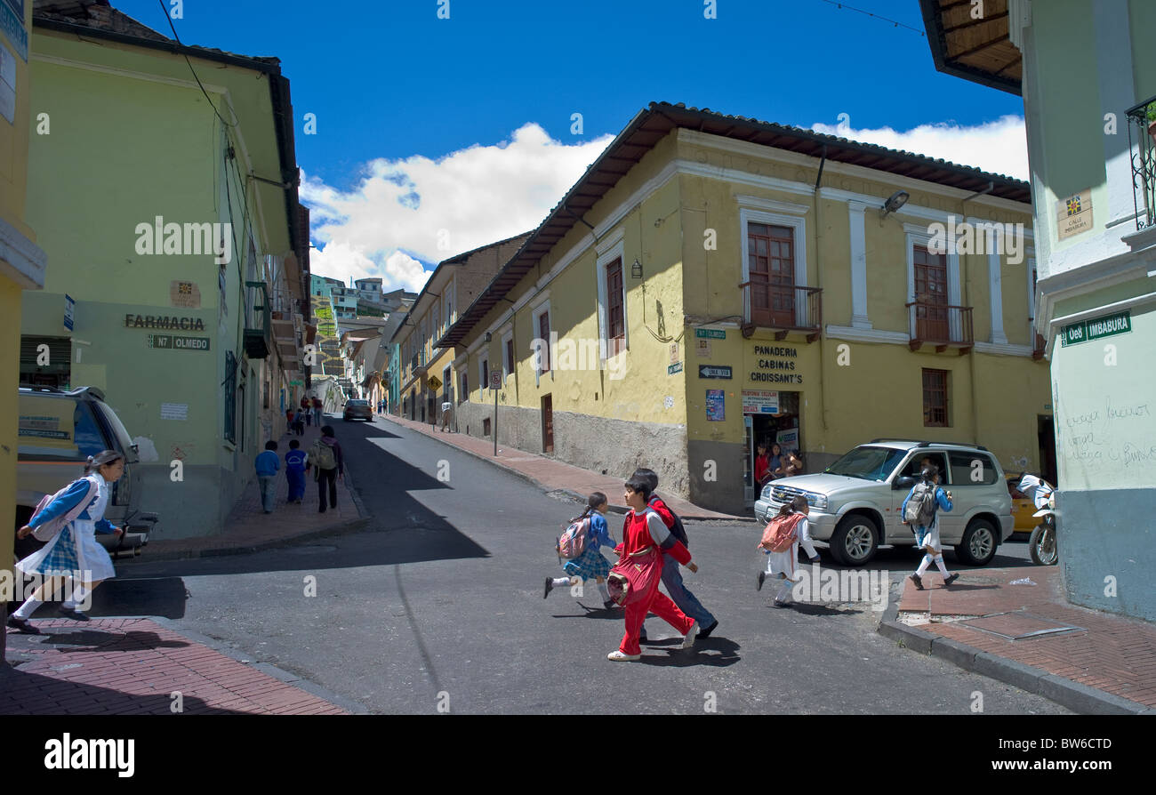 Children rushing across intersection on way home from school for lunch, Quito, Ecuador Stock Photo