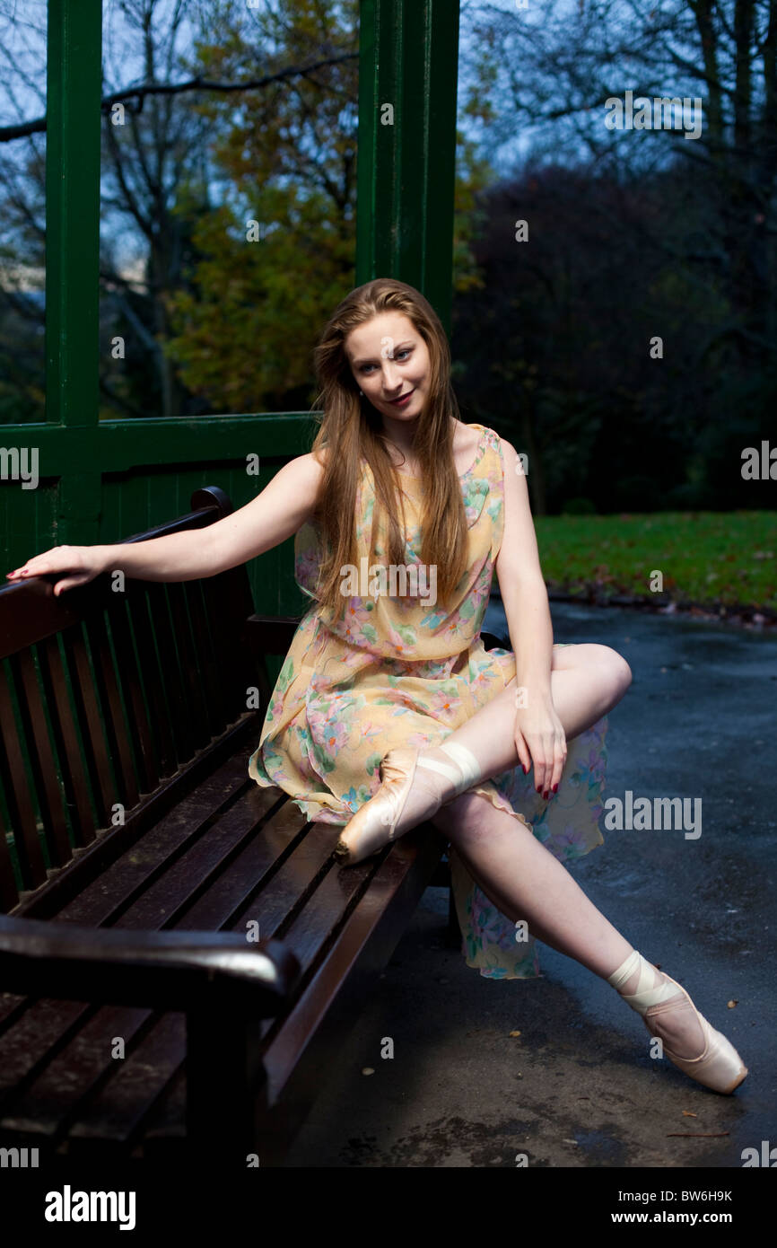 Full length portrait of a ballet dancer seated on a bench wearing pointed shoes, Waterlow Park,  N6, Highgate, London, England, UK Stock Photo
