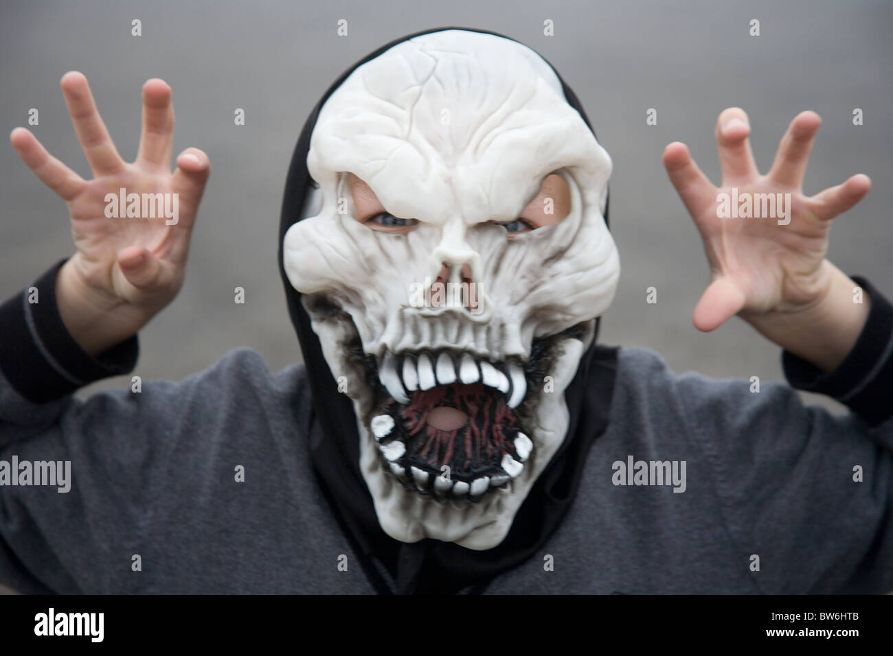Young boy wearing skeleton Halloween mask with scary pose Stock Photo
