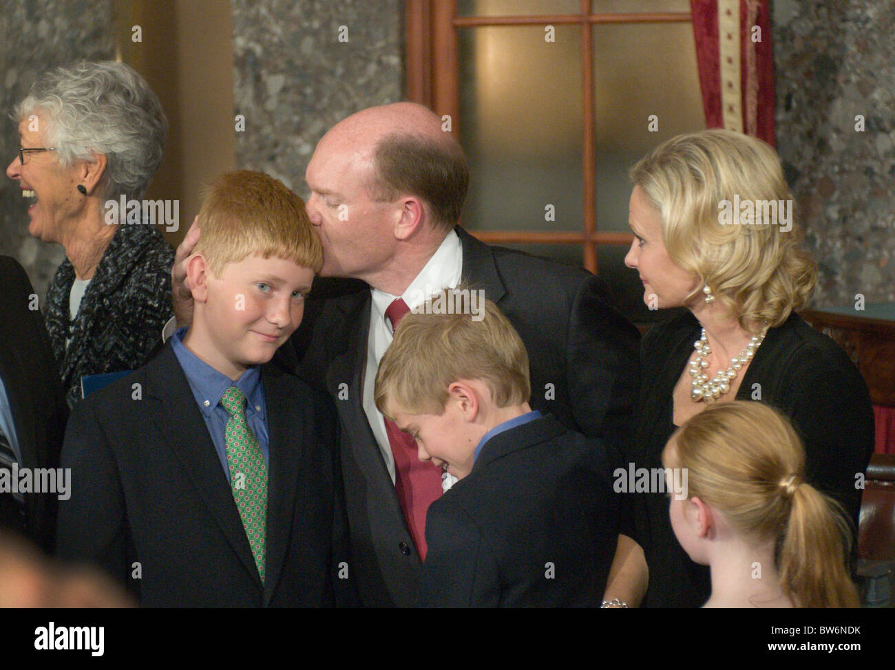 Sen. Chris Coons, D-Del., kisses his son Mike after Vice President Joe Biden performed a ceremonial swearing-in, in the Capitol' Stock Photo