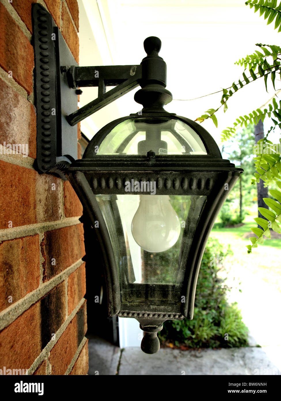Outdoor Residential Light Fixture With White Bulb In A Metal Black Outdoor Residential Light Fixture With White Bulb In A Metal Black Antique Frame On Red Brick Wall Bracket Glass House