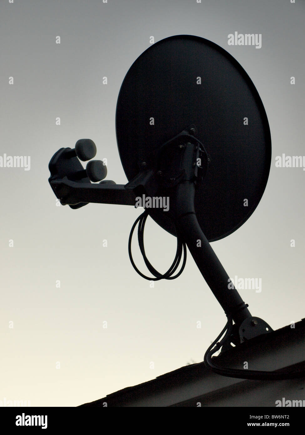 satellite television tv dish on roof sillouette Stock Photo