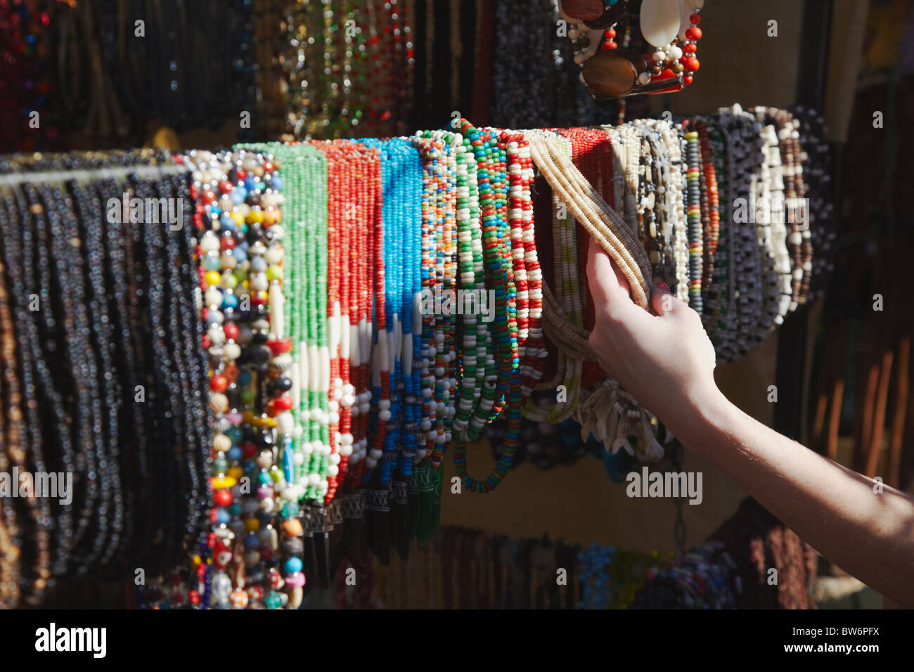 Woman holding souvenir necklaces at Green Market Square, Cape Town