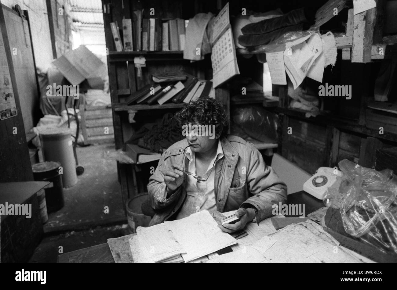 Workplace 1980s UK. Messy untidy office, paper work, Blackburn Lancashire businessman in his dyeing factory 1983 1980s UK HOMER SYKES Stock Photo