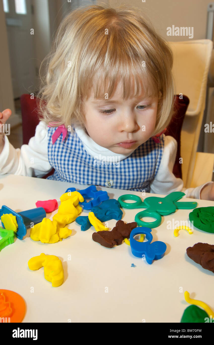 young three year old girl playing with play dough activity Stock Photo