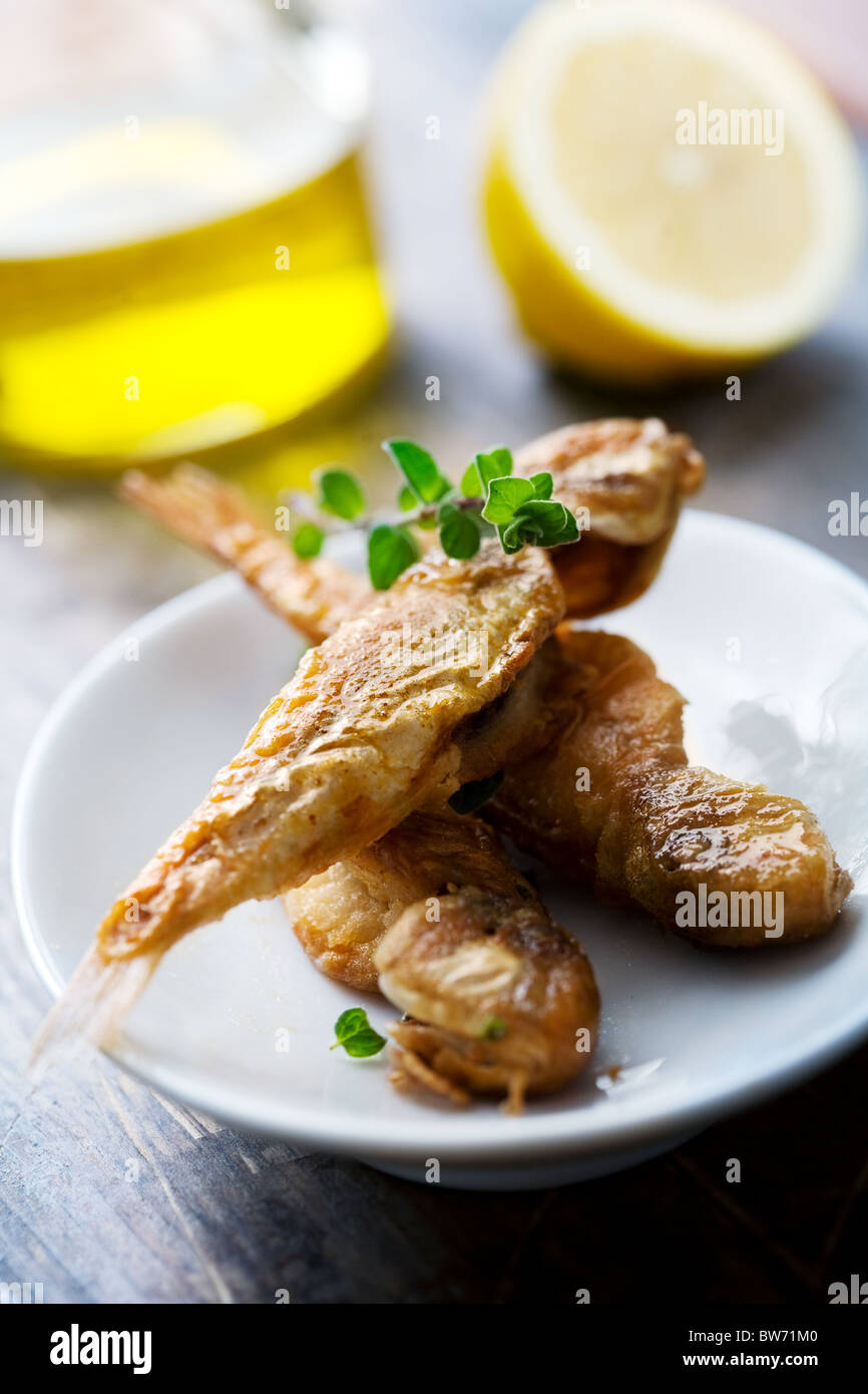 type of small red mullet, fried in olive oil, flour and salt, spinkled with oregano and lemon, a typical mediterranean meze Stock Photo