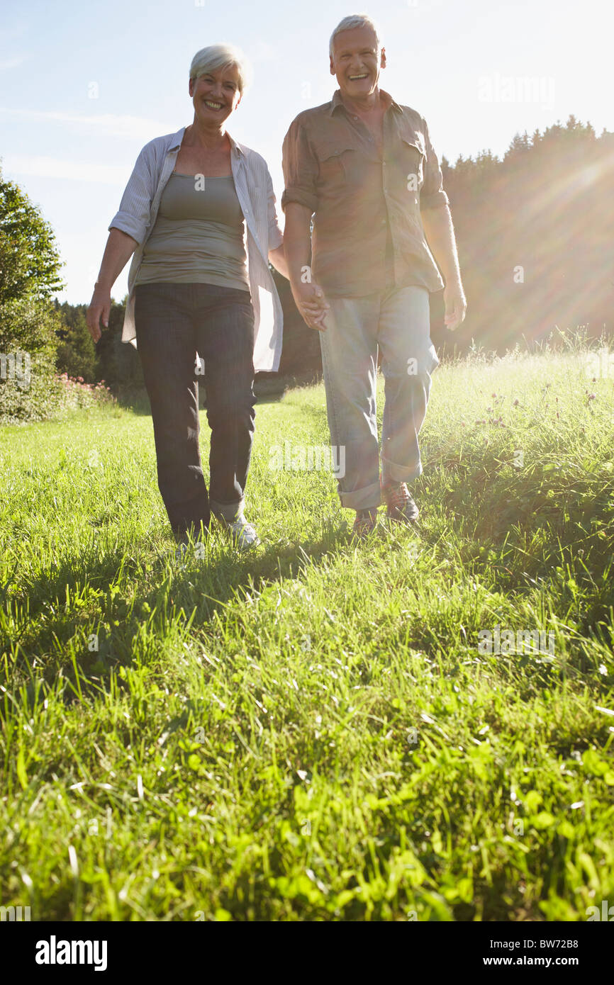 Senior couple walking in meadows Stock Photo