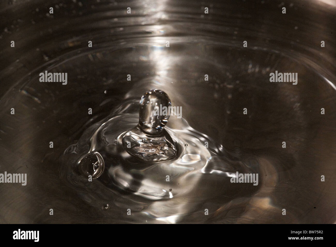 Droplets hitting water surface. Stock Photo