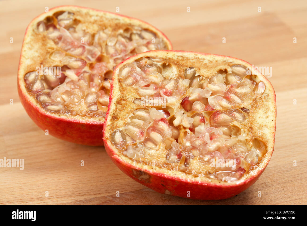 sliced halved pomegranate showing the arils and internal pulp Stock Photo