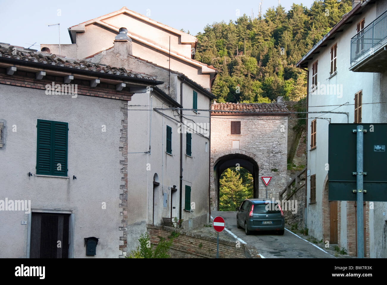 A small car drives through the narrow arch of Porta Romana, Arcevia, Le Marche, Italy Stock Photo
