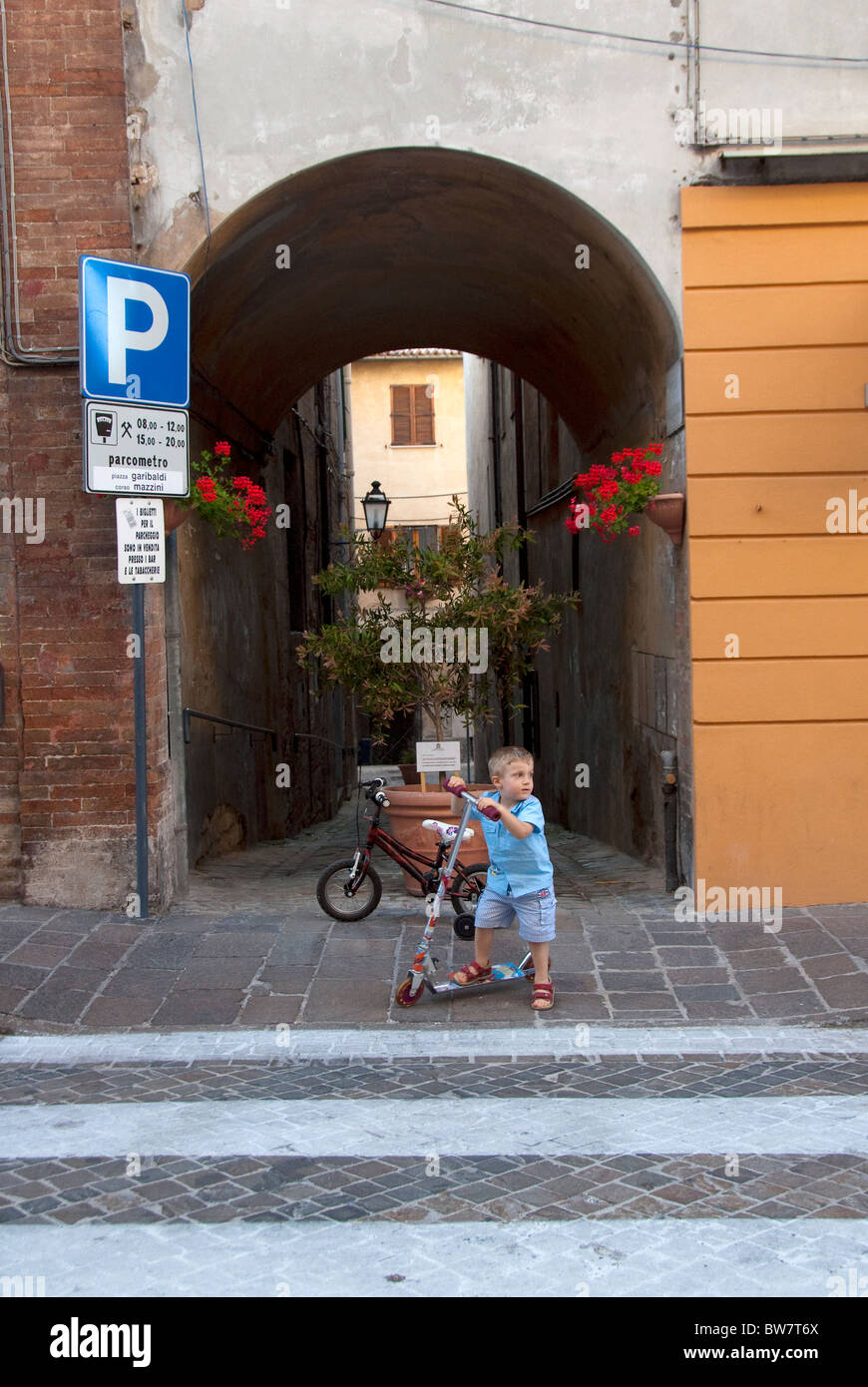 Child on a bicycle in Arcevia, Le Marche, Italy Stock Photo