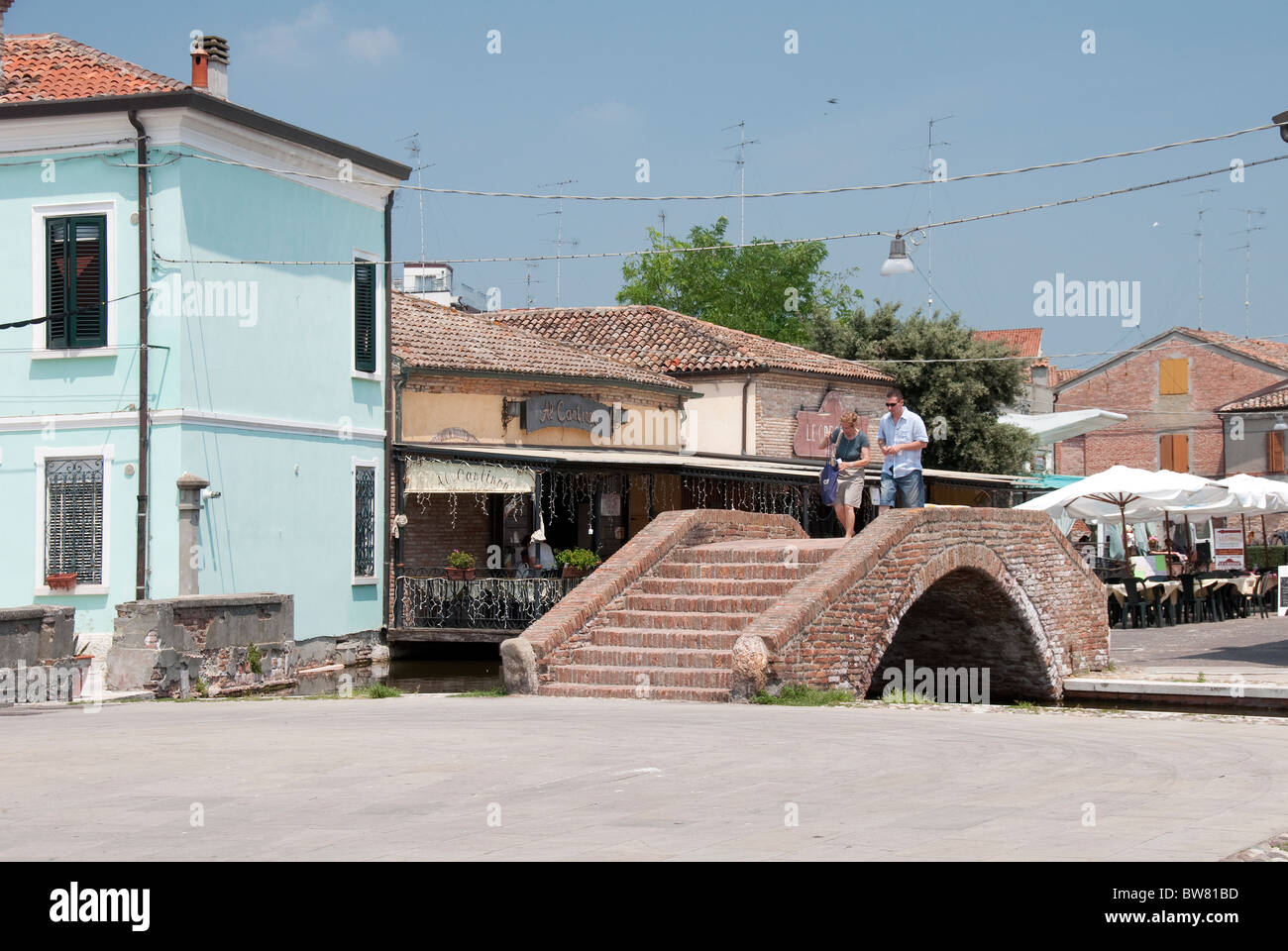 Tourist couple cross a bridge in Comacchio, Emilia Romagna, Italy Stock Photo