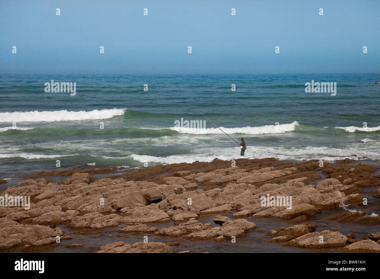 A fisherman with ocean waves on the Corniche in Casablanca, Morocco ...