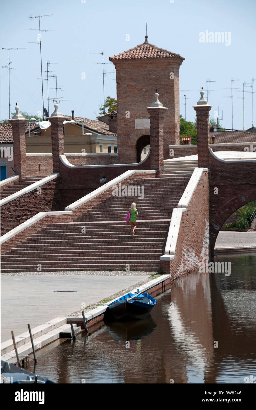 A young blonde woman walks up the stairs of Trepponti, the main sight in Comacchio, Emilia Romagna, Italy Stock Photo