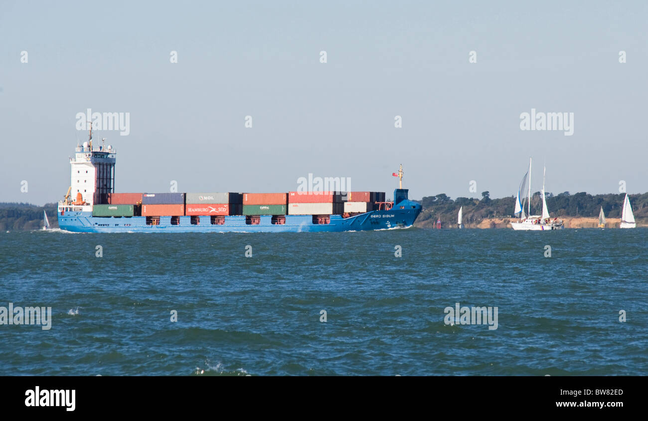 Container ship sailing into Southampton Solent large yachts colourful