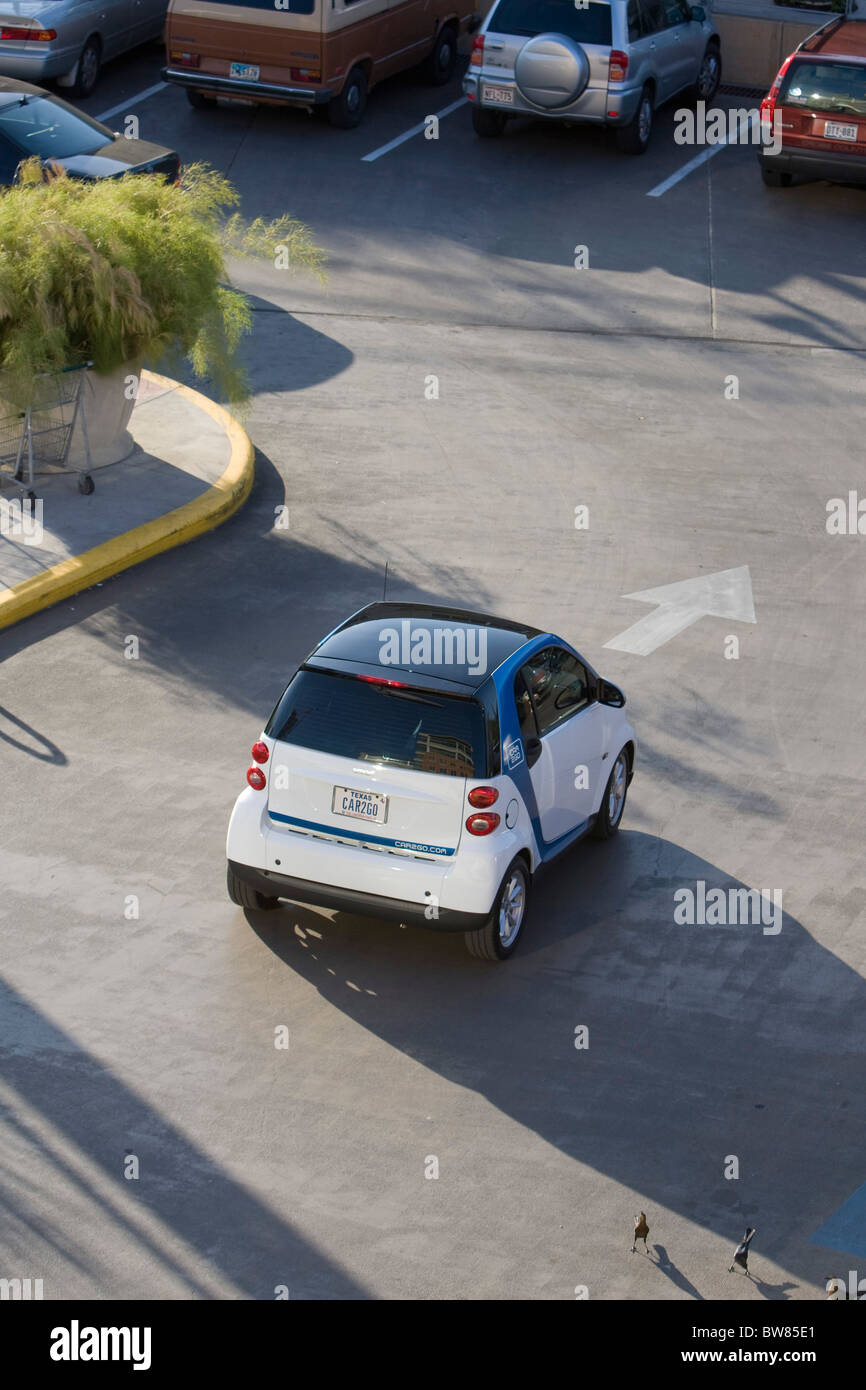 SmartCar Car2Go by Daimler drives through parking lot in Austin, Texas, a test market for the rent-by-the-minute concept car. Stock Photo