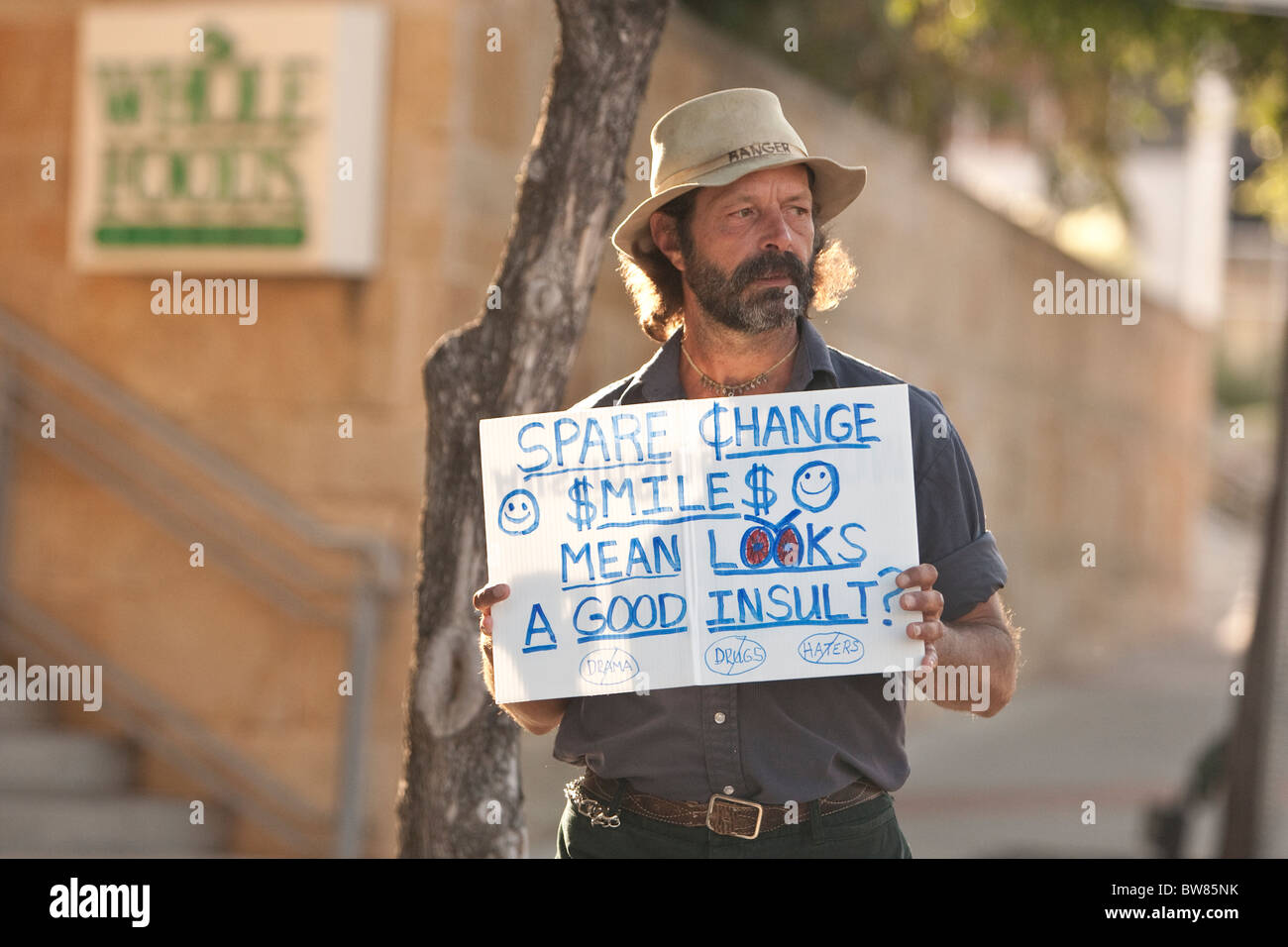 A bearded man looks for spare change on Sixth Street outside the Whole ...