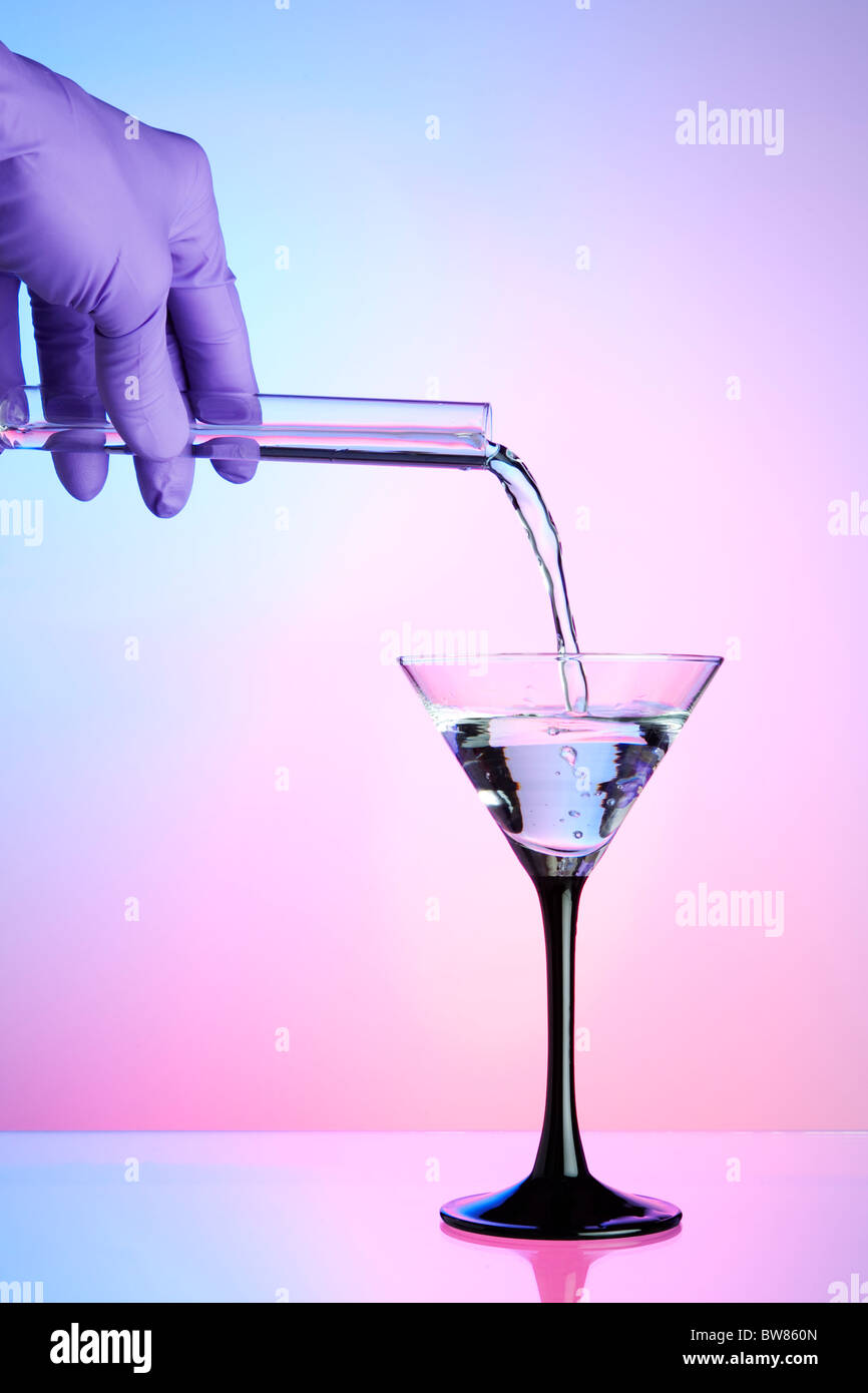 Pouring liquid from a test tube into a cocktail / martini glass Stock