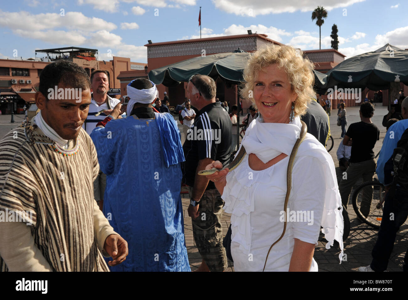 Tourists pay to have their photoraphs taken with snakes in the famous Jemaa El Fna market square in Marrakesh Morocco Stock Photo