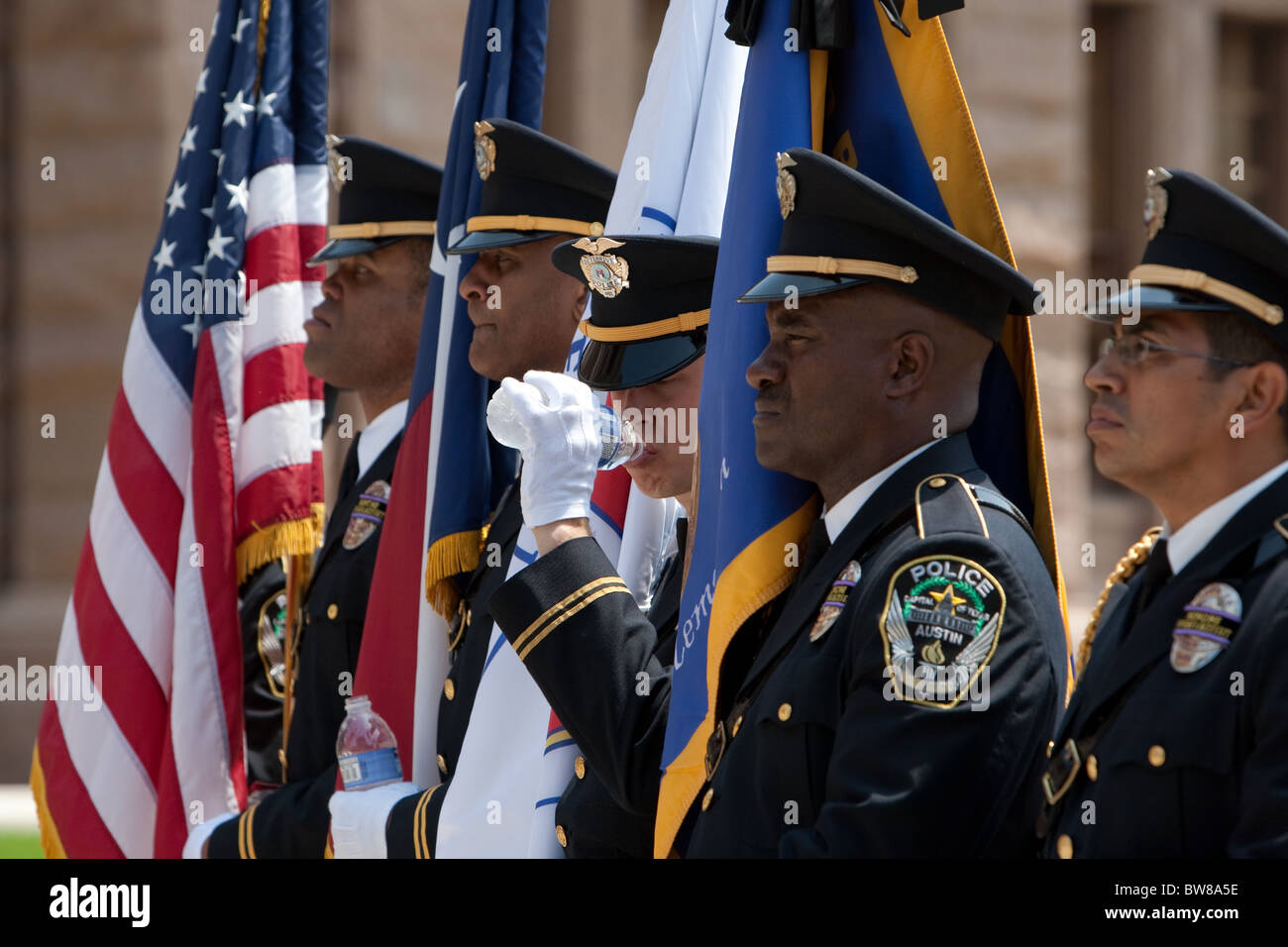 Multi-ethnic group of police officers present flags as color guard during Peace Officers Memorial Day ceremony in Austin, Texas Stock Photo