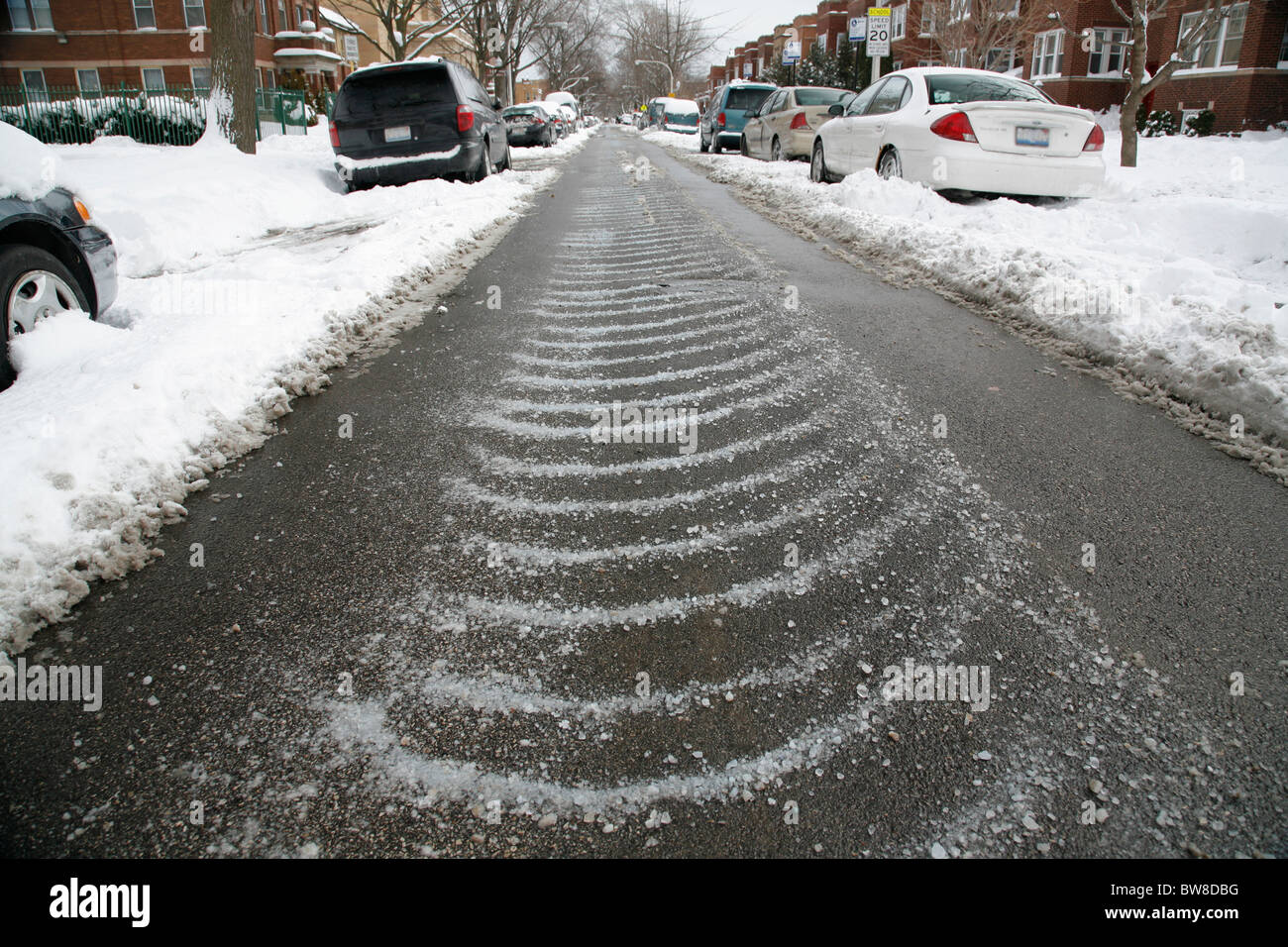 wet plowed street with salt to melt ice and snow in winter Stock Photo