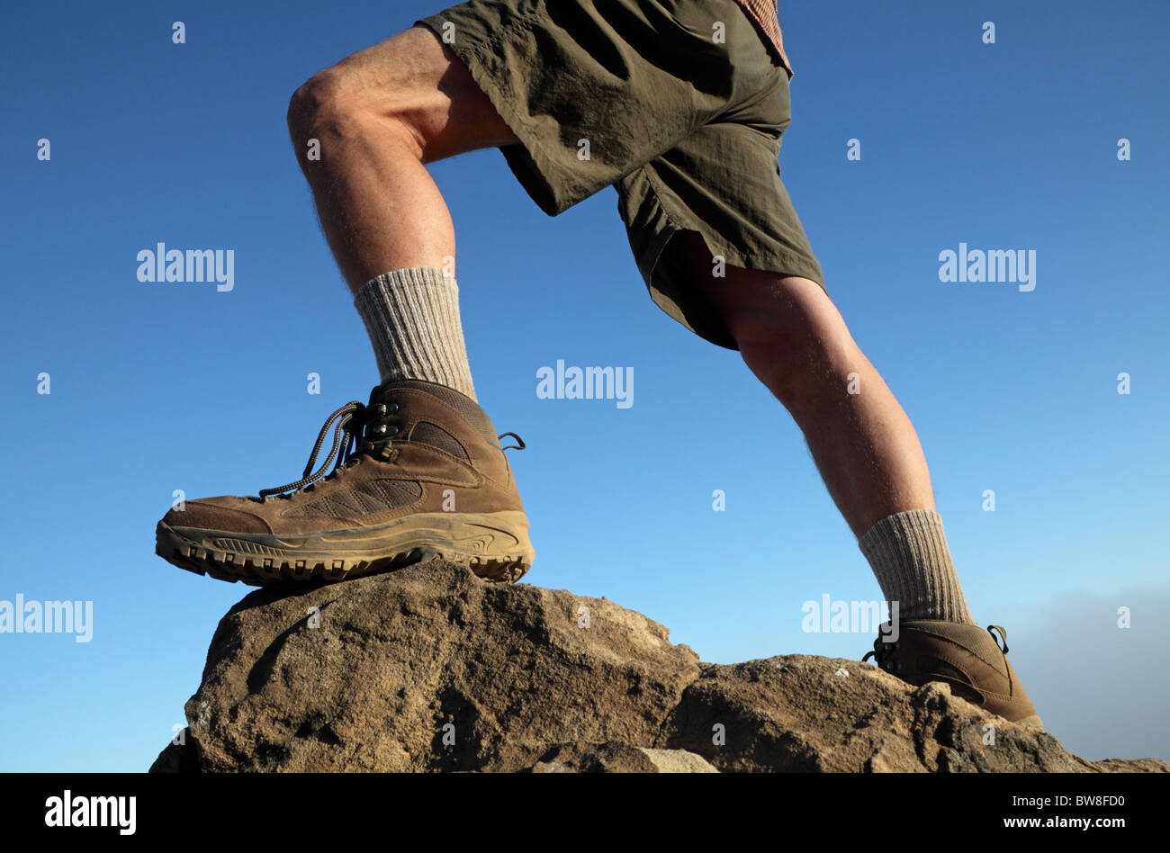 Hiker stands atop boulders in Temescal Canyon Gateway Park, which traverses Topanga State Park in Southern California Stock Photo