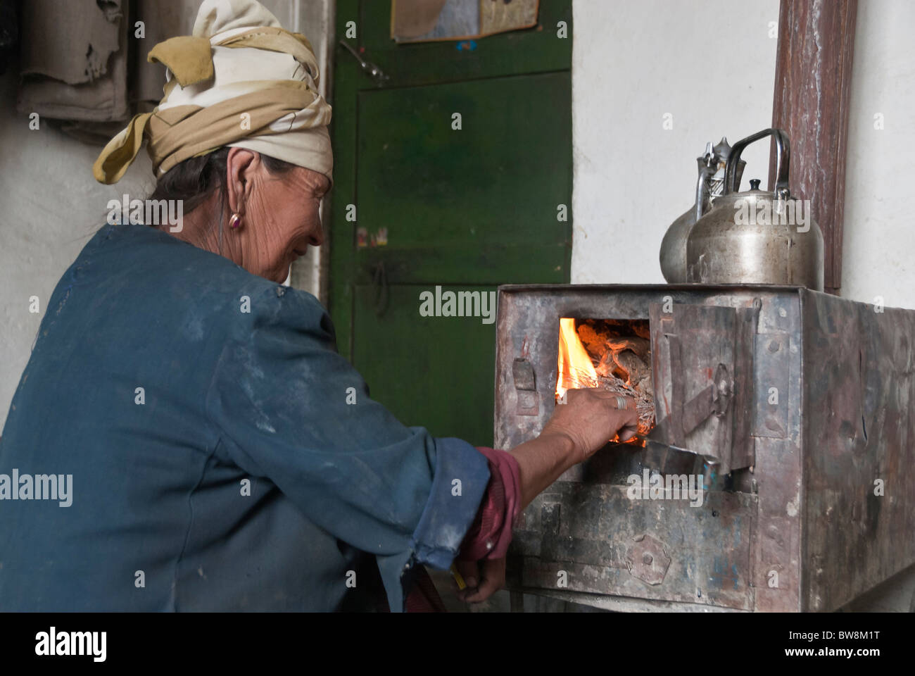 Woman lighting a fire. Murgab, Pamir highway, Tajikistan, Asia Stock Photo