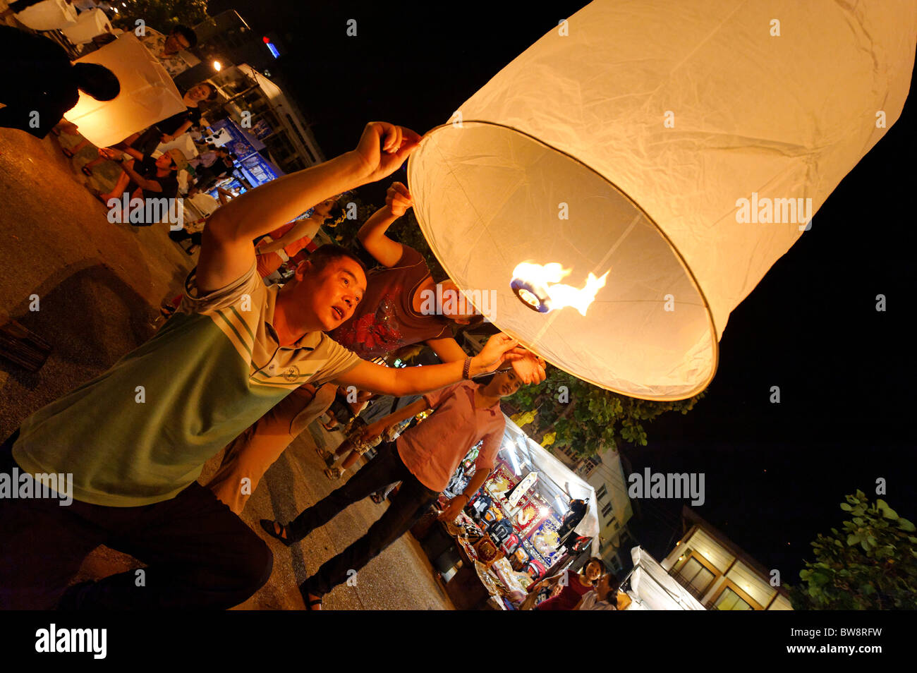 Lighting a Lantern at Loi Krathong, Chiang Mai Stock Photo