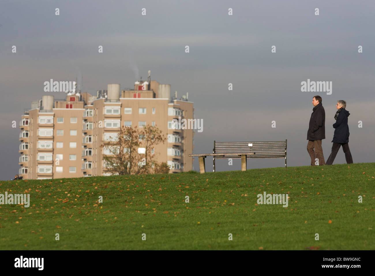 Local middle-aged couple and high-rise flats seen from Brockwell Park, Herne Hill, South London. Stock Photo