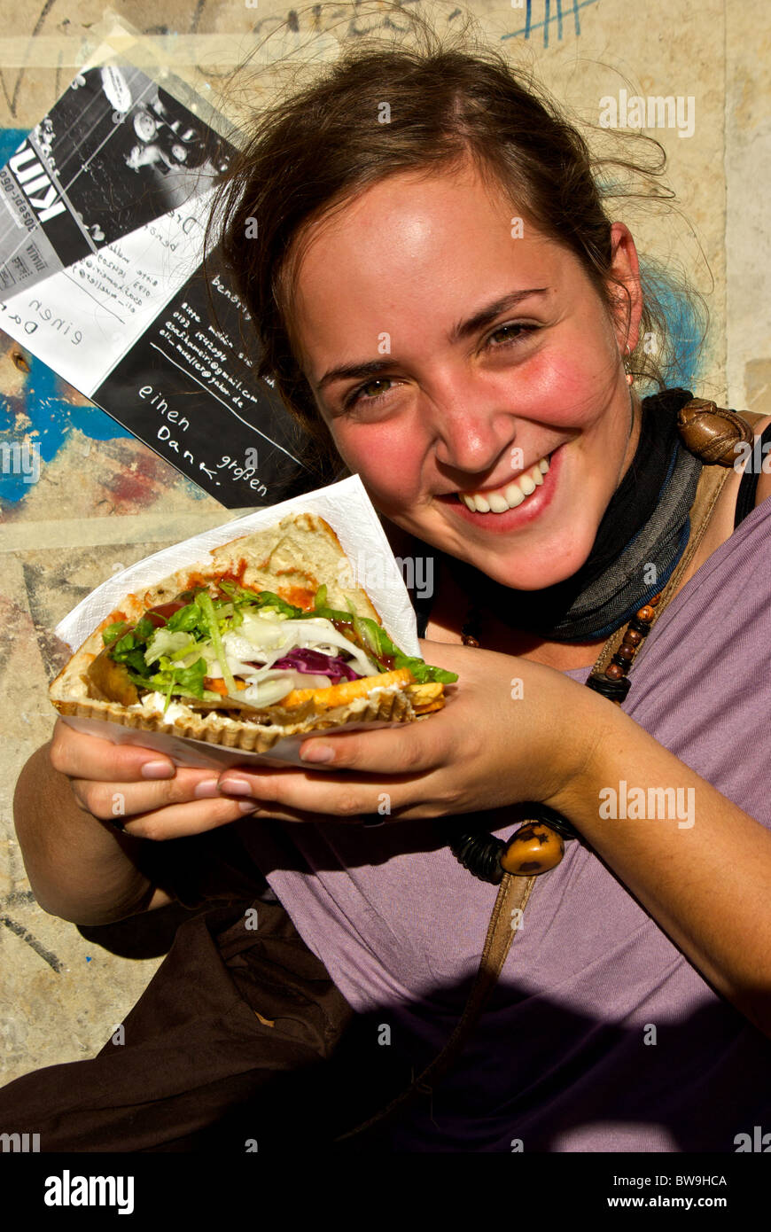 Pretty young American female holding enormous vegetarian pita pocket takeout sandwich in Dresden new town neustadt Stock Photo